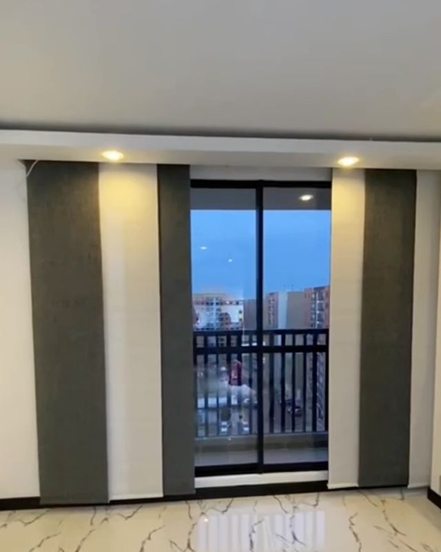 Apartamento con panel japonés motorizado a ambos lados del ventanal