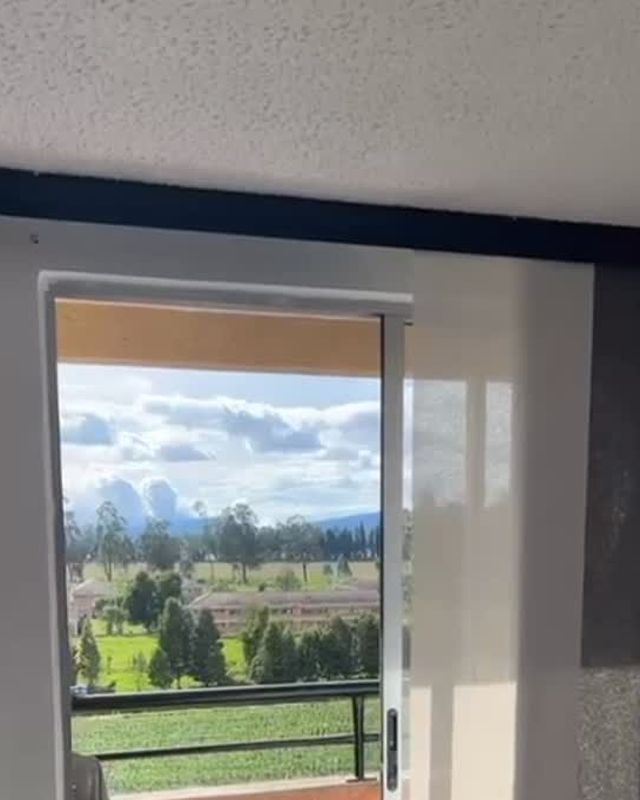 Panel japonés instalado frente a un ventanal con vista a la sabana